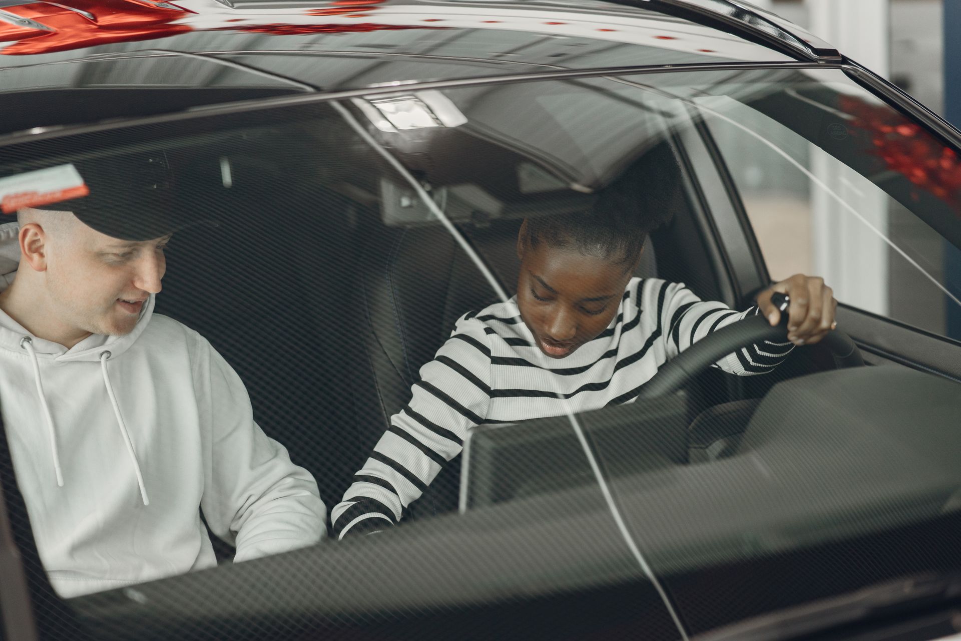 Instructor guiding a student behind the wheel